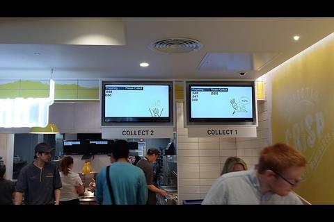 Screens above the servery convey the readiness of the ordered food items